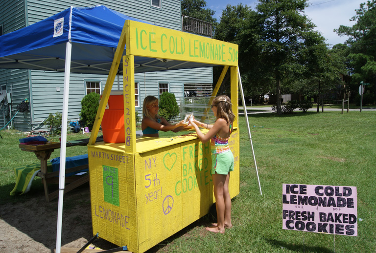 Cassidy Joyce with a customer at her lemonade stand on Martin St. in 