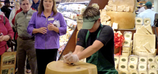 Pam Rosencrans crack a wheel of Parmigiano-Reggiano--signifying the grand opening.