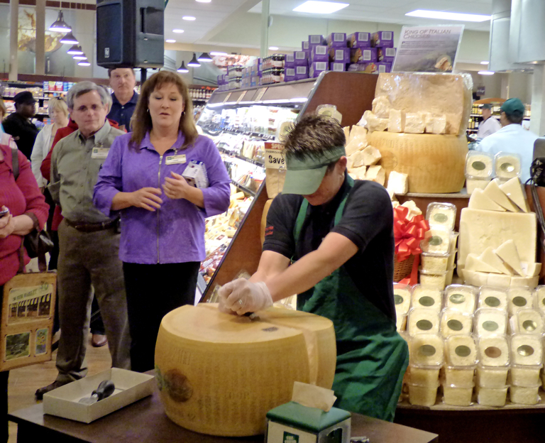 Pam Rosencrans crack a wheel of Parmigiano-Reggiano--signifying the grand opening.