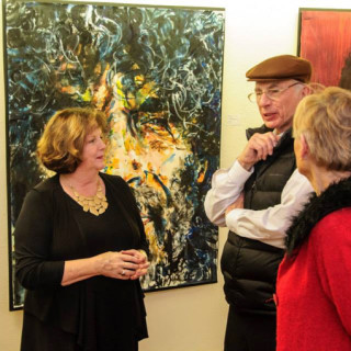 Jesi Pace-Berkeley (in black) standing in front of one of her works at Glenn Eure's Ghost Fleet Gallery.