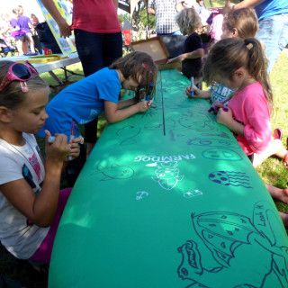 Decorating the Farmdog Surfboard at the 25th Annual DCAC Artrageous.