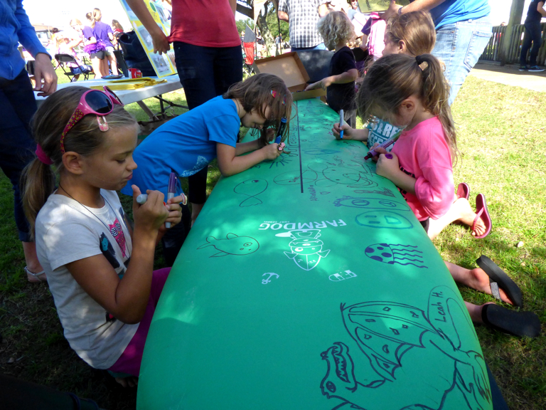 Decorating the Farmdog Surfboard at the 25th Annual DCAC Artrageous.