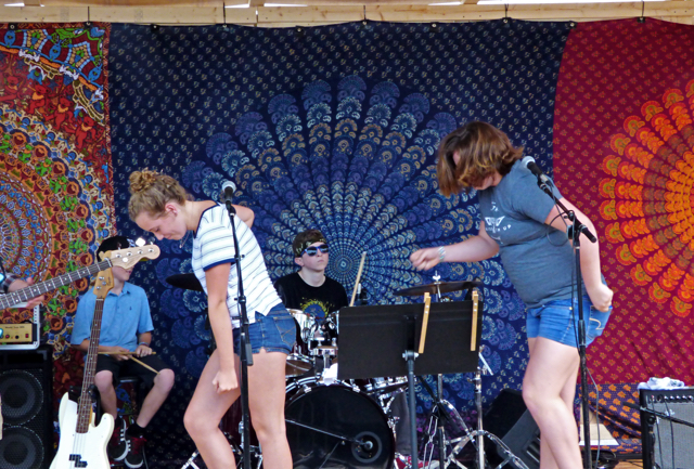 Kamea Blake and Grace Deichler showing some funky moves performing Uptown Funk, with Jonah Wills on drums.