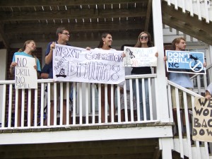 Members of the Manteo High School Environmental Action Committee holding up signs after being told to leave the sidewalk.