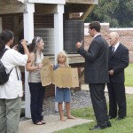 Get off the sidewalk. Members of Governor McCrory's team confront protestors behind the old Dare County Courthouse. Doug Kenyon with camera and Amanda Hooper with sign reading, "Weigh the Risks." Photo Kip Tabb