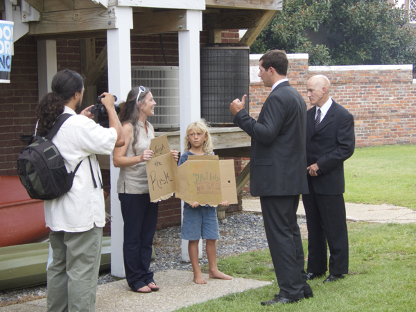 Get off the sidewalk. Members of Governor McCrory's team confront protestors behind the old Dare County Courthouse.  Doug Kenyon with camera and Amanda Hooper with sign reading, "Weigh the Risks." Photo Kip Tabb