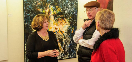Jesi Pace-Berkeley (in black) standing in front of one of her works at Glenn Eure's Ghost Fleet Gallery.