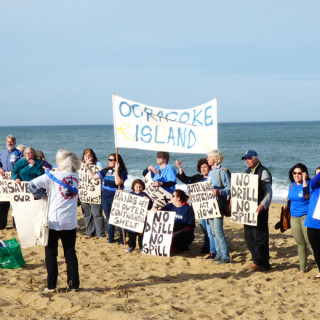 Organizing on the beach for a group photo. The signs from Ocracoke were brought out of the closet from the attempt in the 1990s to lease oil/gas sites off North Carolina.