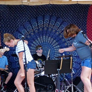 Kamea Blake and Grace Deichler showing some funky moves performing Uptown Funk, with Jonah Wills on drums.